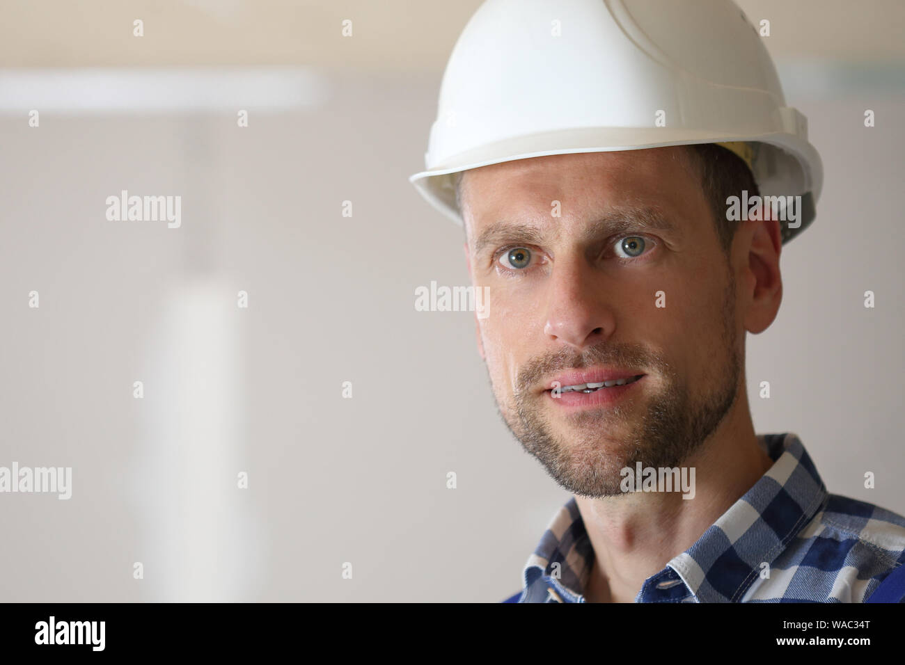 Un uomo con il casco di sicurezza in verticale Foto Stock