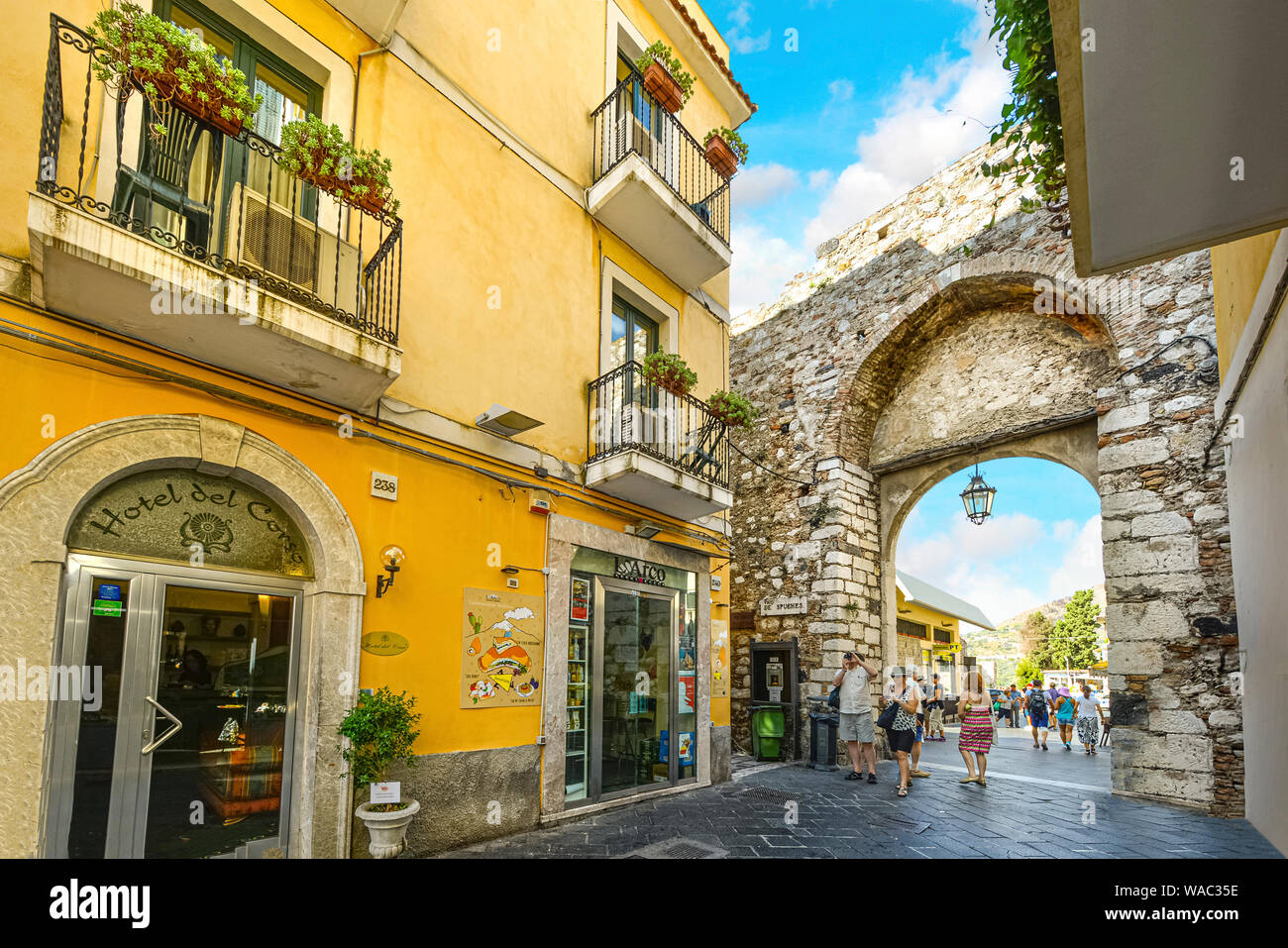 I turisti passano attraverso la vecchia città di pietra porta d'ingresso nella pittoresca città di Taormina in Sicilia in Italia Foto Stock
