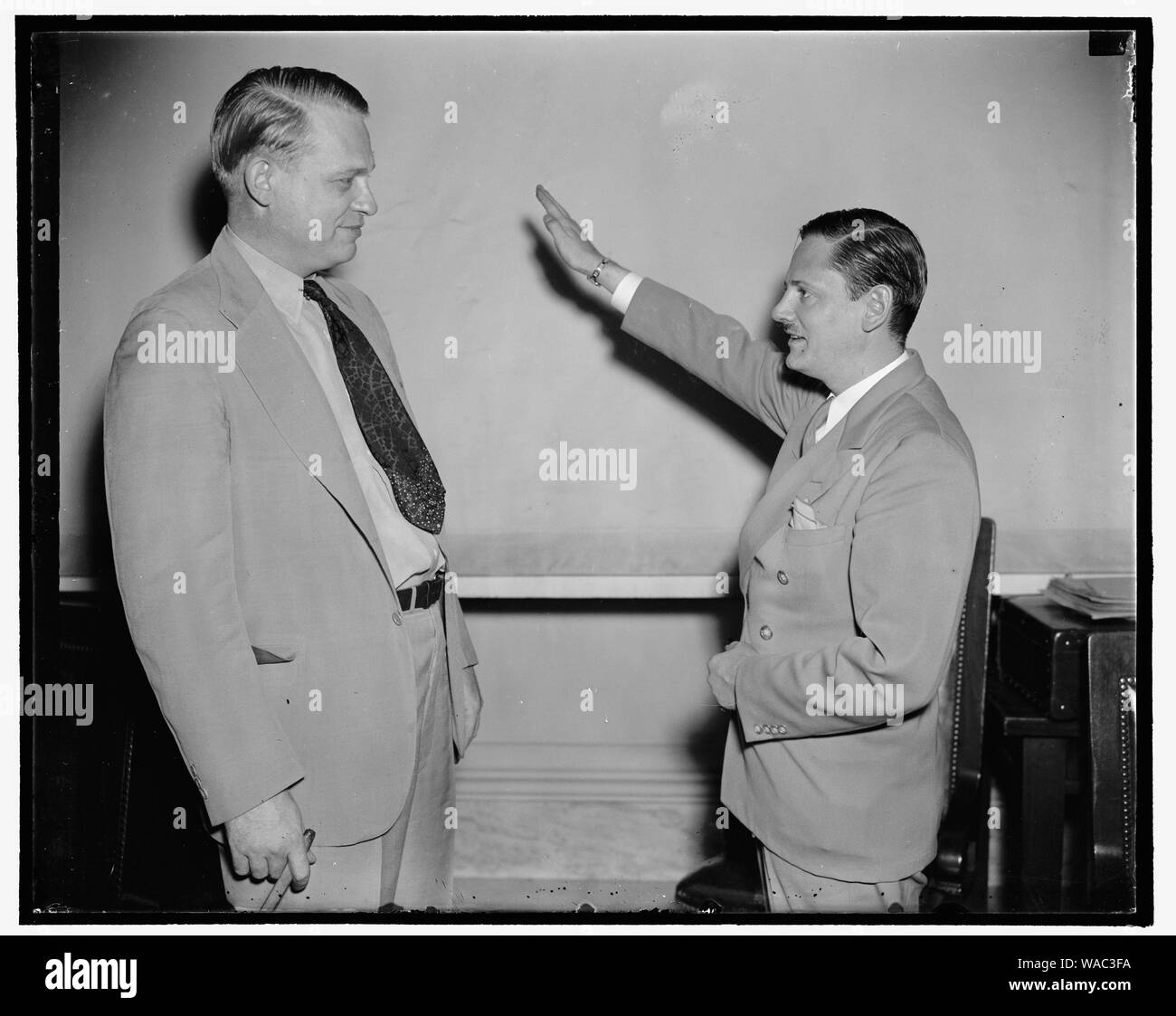 Heil Hitler salutate dato presidente del Comitato Casa studiando un-American attività dalla prima testimonianza. Washington, 12 agosto. Chiamato come la prima testimonianza davanti la casa speciale Commissione indagando Un-American attività, John Metcalfe, ex reporter di Chicago ma ora un investigatore per il comitato dà Presidente Martin muore (a destra) un saluto nazista prima di prendere il cavalletto. Unire sotto il nome di Hellmut Oberwinder, Metcalfe legate le sue esperienze come membro del tedesco-americana bund e addebitato l organizzazione ha una relazione segreta con il governo nazista in tedesco Foto Stock