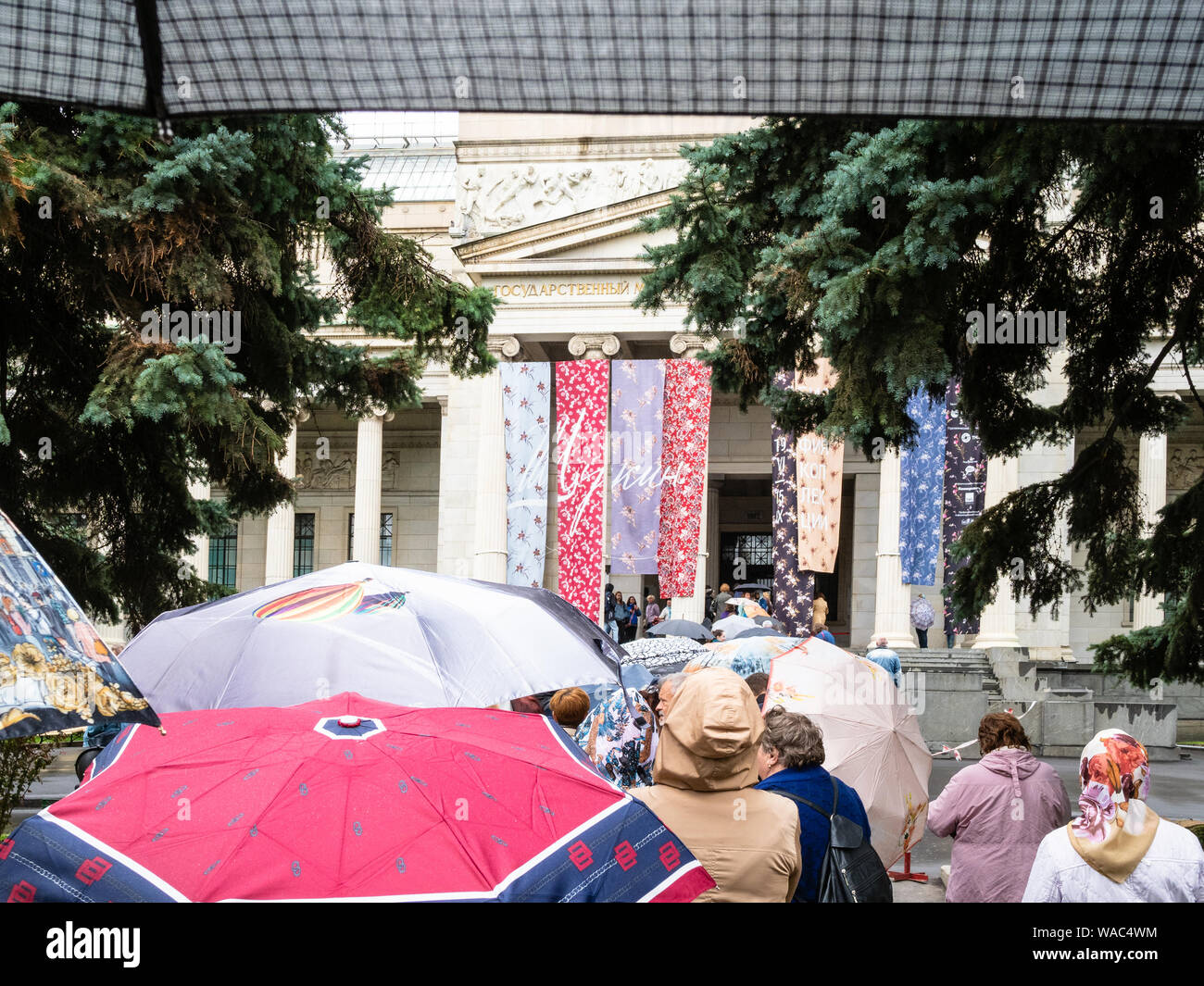 Mosca, Russia - 31 luglio 2019: linea di visitatori con ombrelloni vicino a Pushkin Museo Statale di Belle Arti a Mosca in caso di pioggia. Museo Puskin è il museo Foto Stock