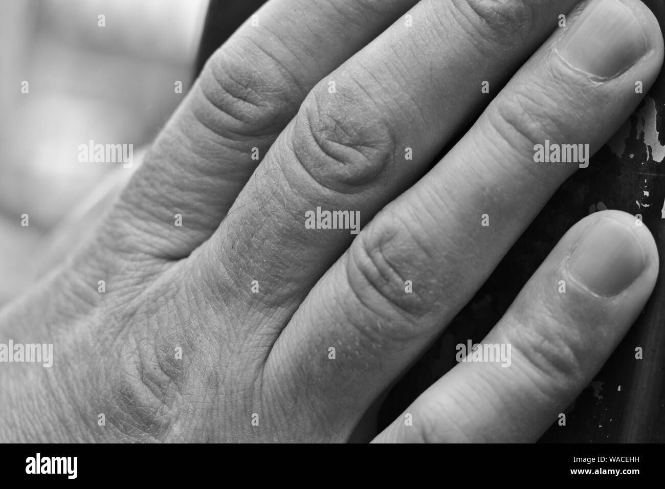 Mano che tiene al palo della luce. Foto Stock