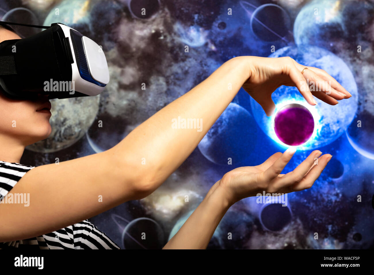 Una donna sta guardando attraverso la realtà virtuale nello spazio. Sfondo spazio Foto Stock