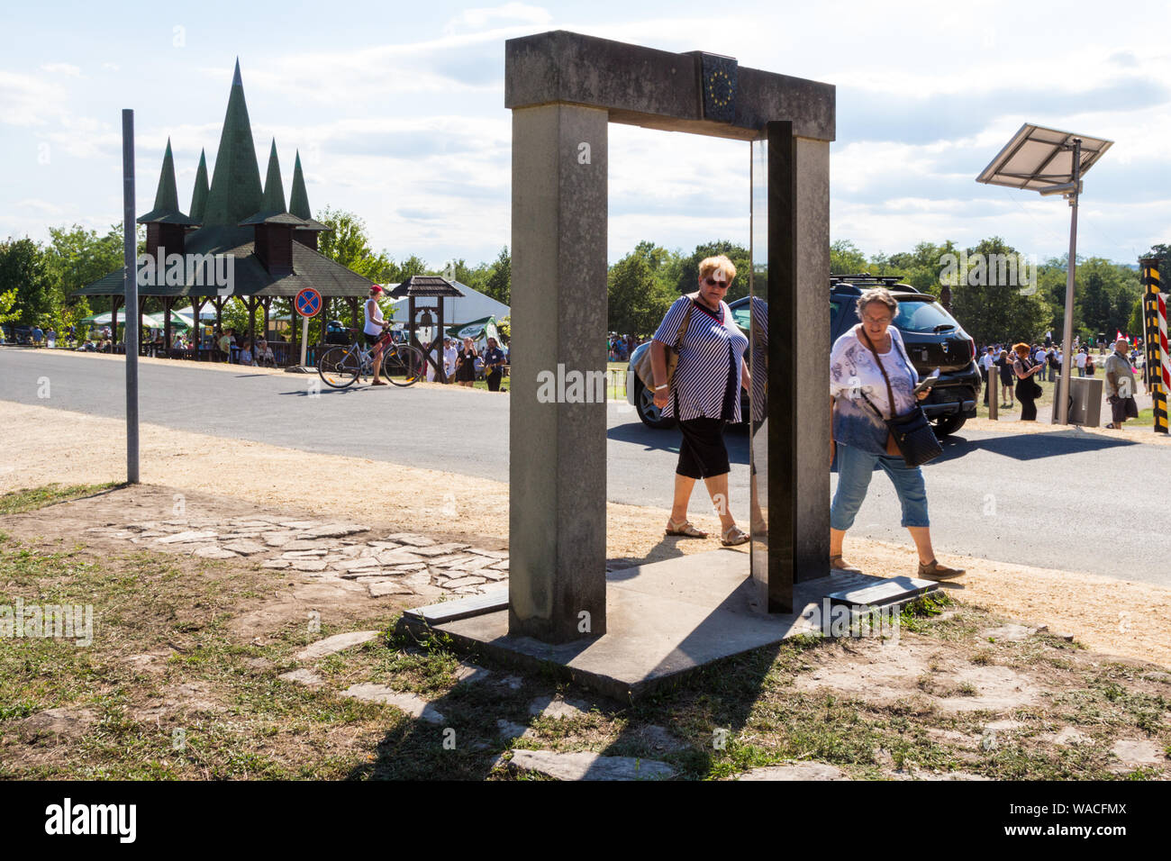 Persone che guardano la statua di gate per il trentesimo anniversario del picnic paneuropeo in Fertorakos, Ungheria Foto Stock