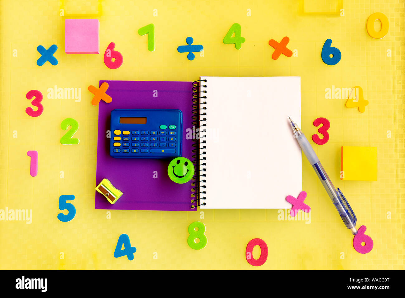 Sfondo bianco con notepad circondato da numeri di variopinti e una calcolatrice per imparare la matematica Foto Stock