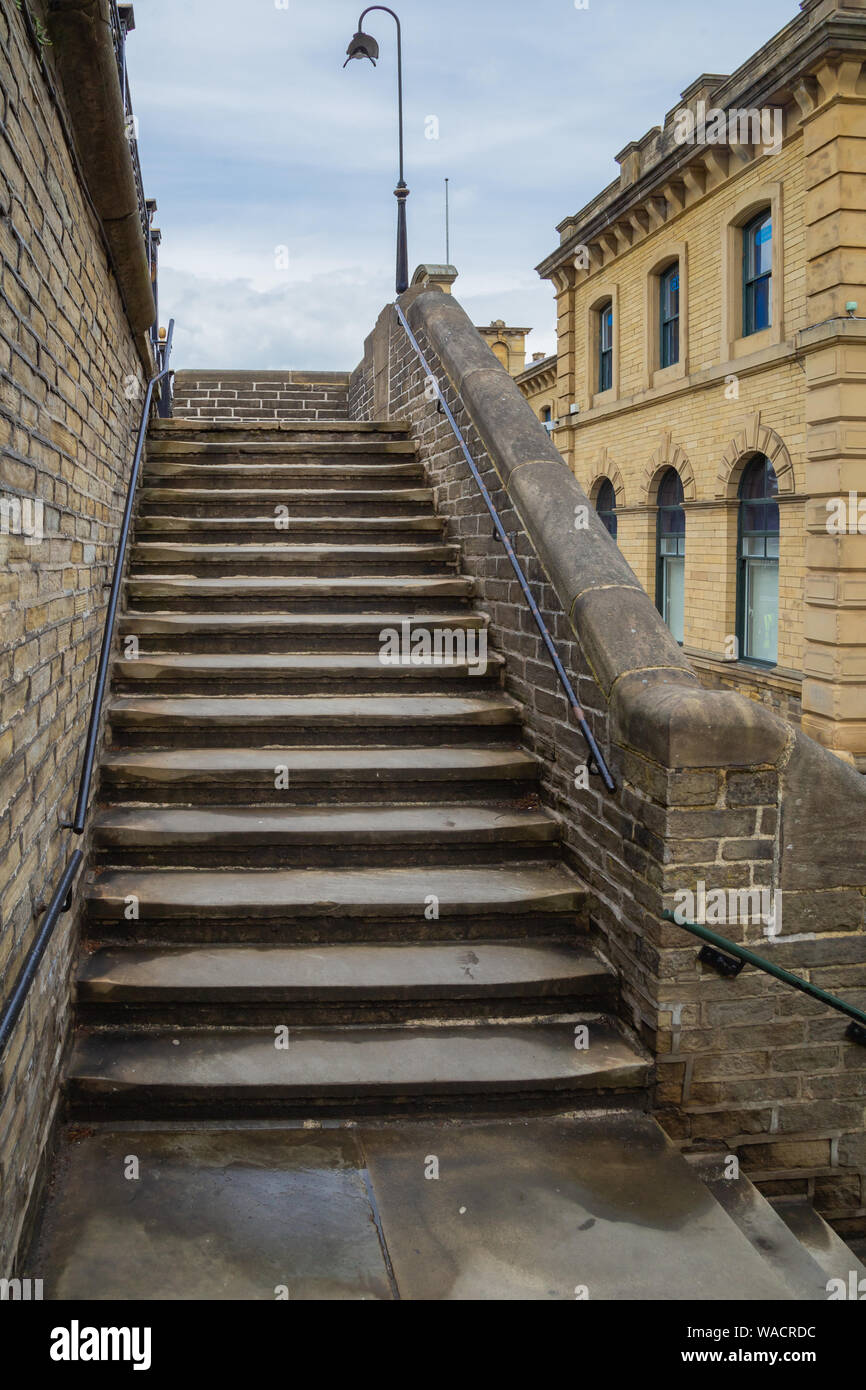 Millworkers passi fuori Salts Mill in Saltaire, Yorkshire.i passi conducono dall'esterno del mulino fino al marciapiede. Foto Stock