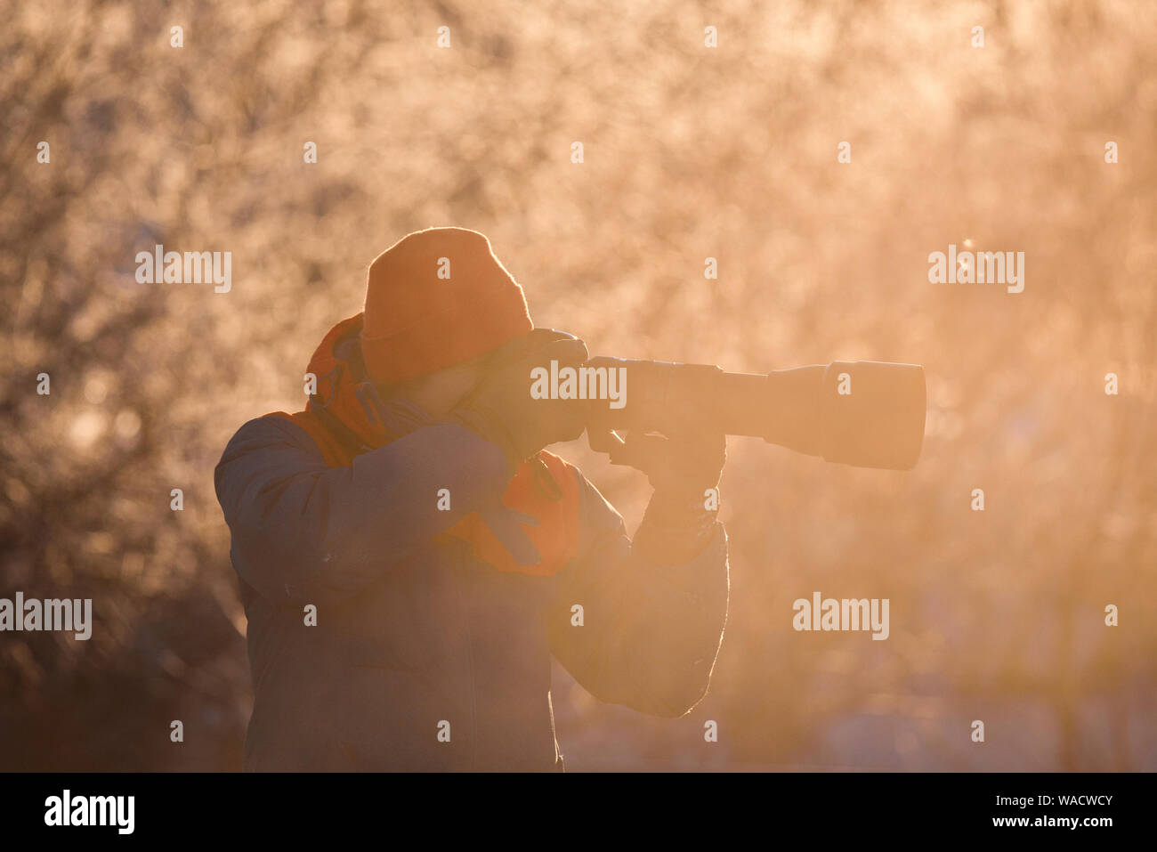 Lebedinyj Swan Riserva Naturale, Altai, Russia - 23 Febbraio 2019: un fotografo con una telecamera e un teleobiettivo germogli su un gelido inverno mattina Foto Stock