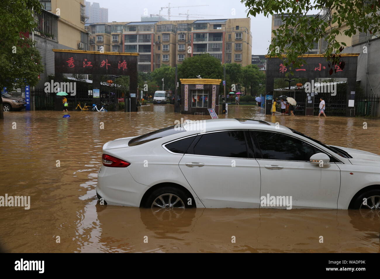 Un auto è semi-sommersa in una strada allagata causato da una pioggia torrenziale nella città di Yichun, Cina orientale della provincia di Jiangxi, 9 luglio 2019. Un totale di 19,91 m Foto Stock