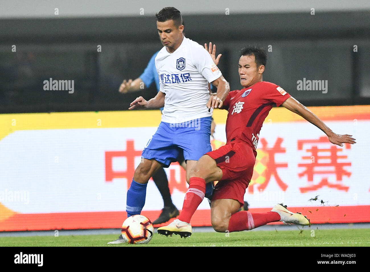 Il calcio brasiliano player Johnathan Aparecido da Silva, comunemente noto come Johnathan, sinistra, di Tianjin TEDA passa la palla contro un giocatore di Tianjin Foto Stock