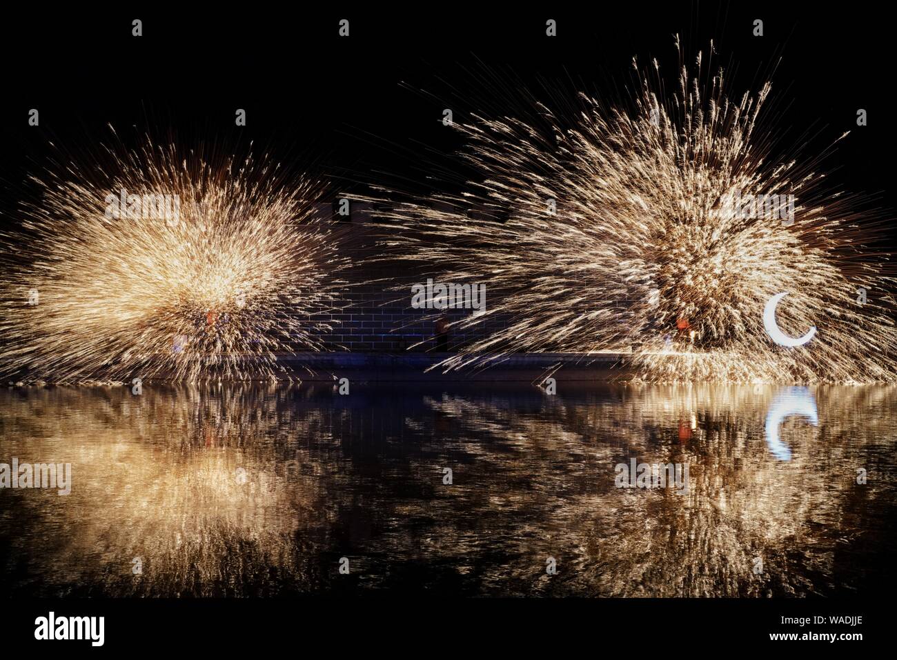 La formazione di scintille creato da ferro fuso sono acqua schizzava alta nel cielo durante una performance di Datiehua, o "battere il ferro fiori', al mondo di Pechino Foto Stock