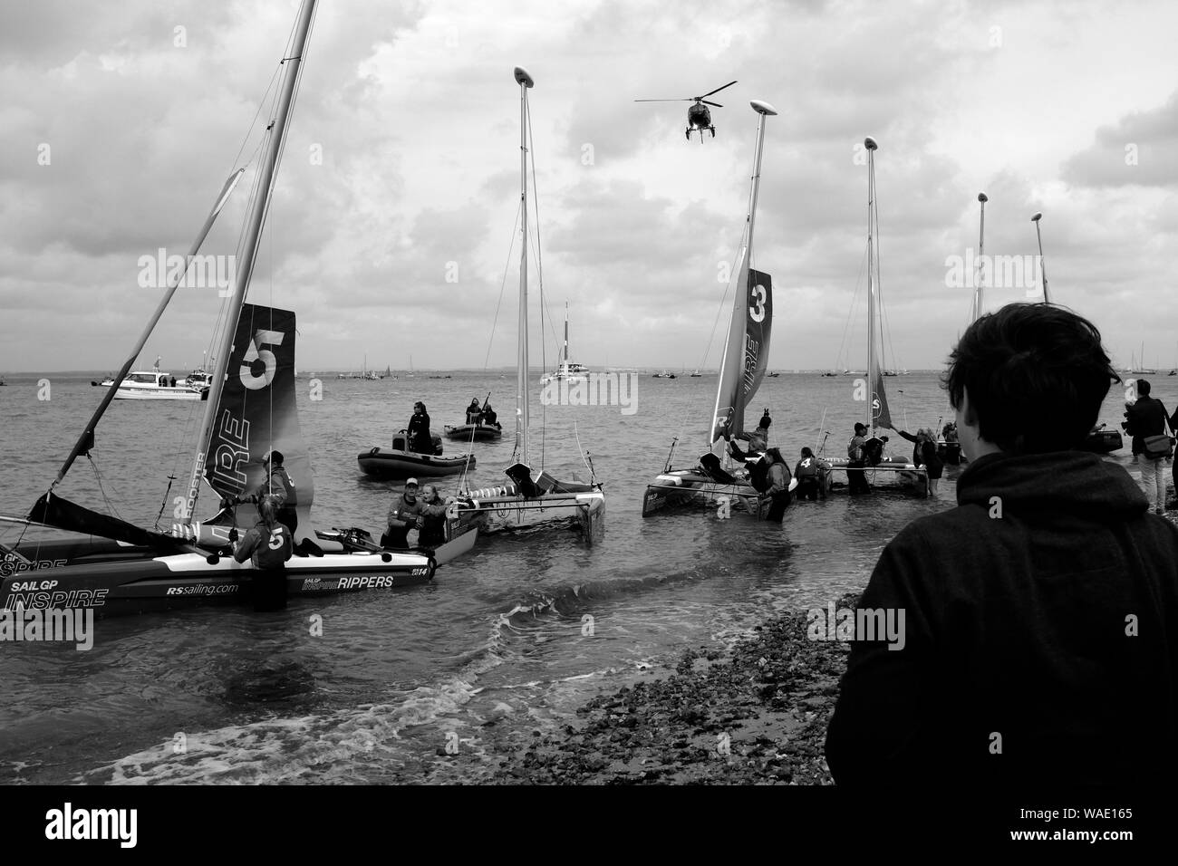 Small double hull yacht racing appena fuori dalla spiaggia a Cowes lungomare sulla isola di Wight Foto Stock