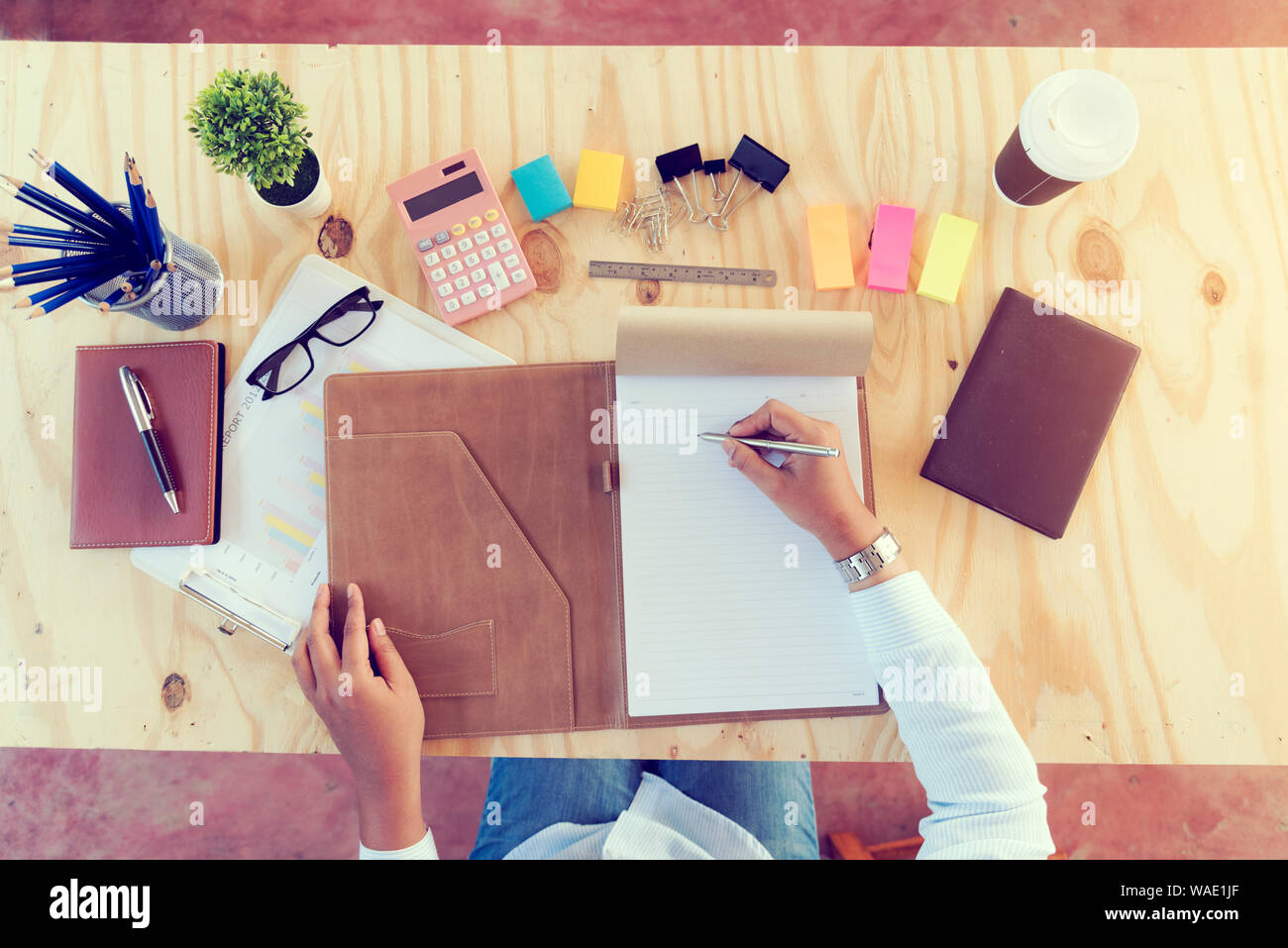 Vista superiore del giovane bella donna d'affari scrivendo sul proprio portatile alla sua scrivania con business stuff e tablet. Il concetto di business. Foto Stock