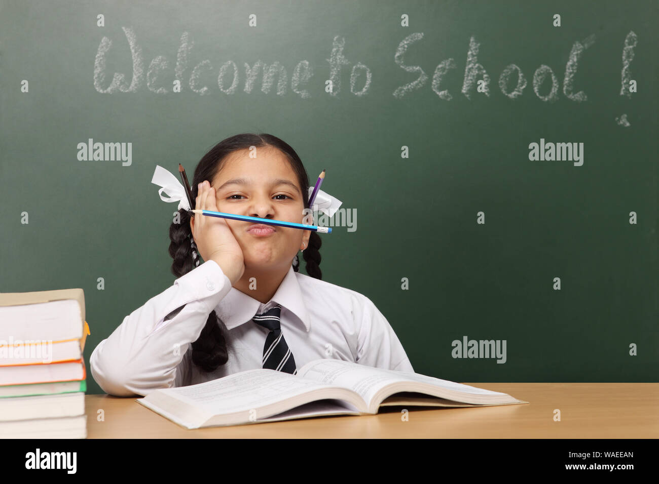Studentessa che tiene la matita sotto il naso Foto Stock