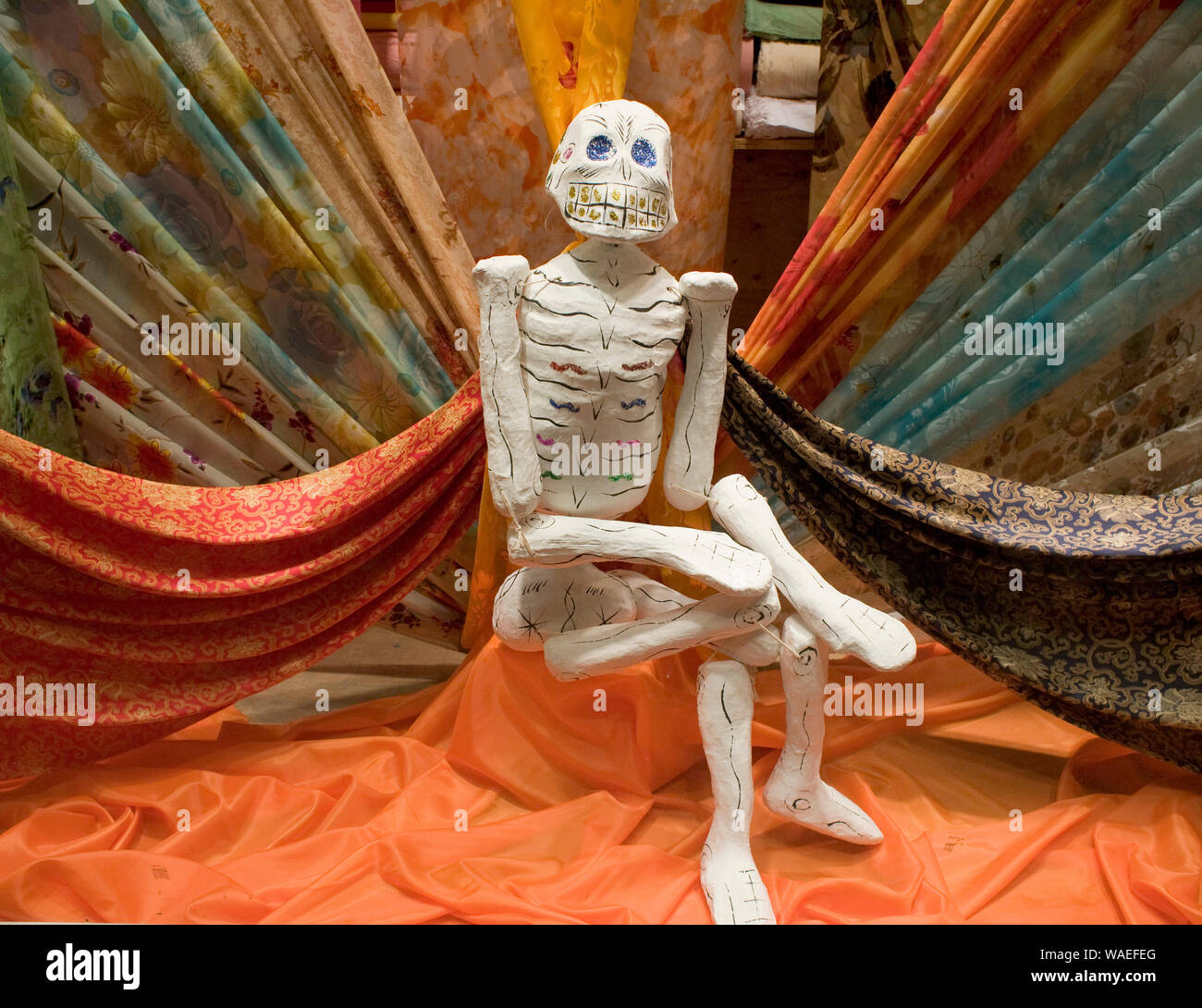 Lo scheletro di tradizionale decor locale per il Giorno dei Morti festival in tessuto store window, città di Oaxaca, Oaxaca, Messico festività locali Foto Stock