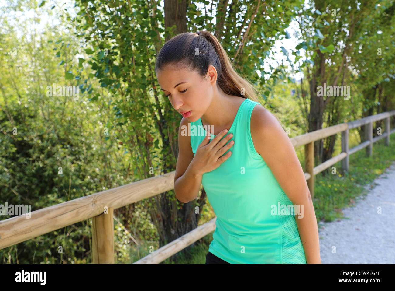 Esecuzione di nausea. La nausea e mal malati runner vomito. Esecuzione di sentimento donna male circa a vomitare. Ragazza avente nausea dalla disidratazione o dolore al petto. Foto Stock