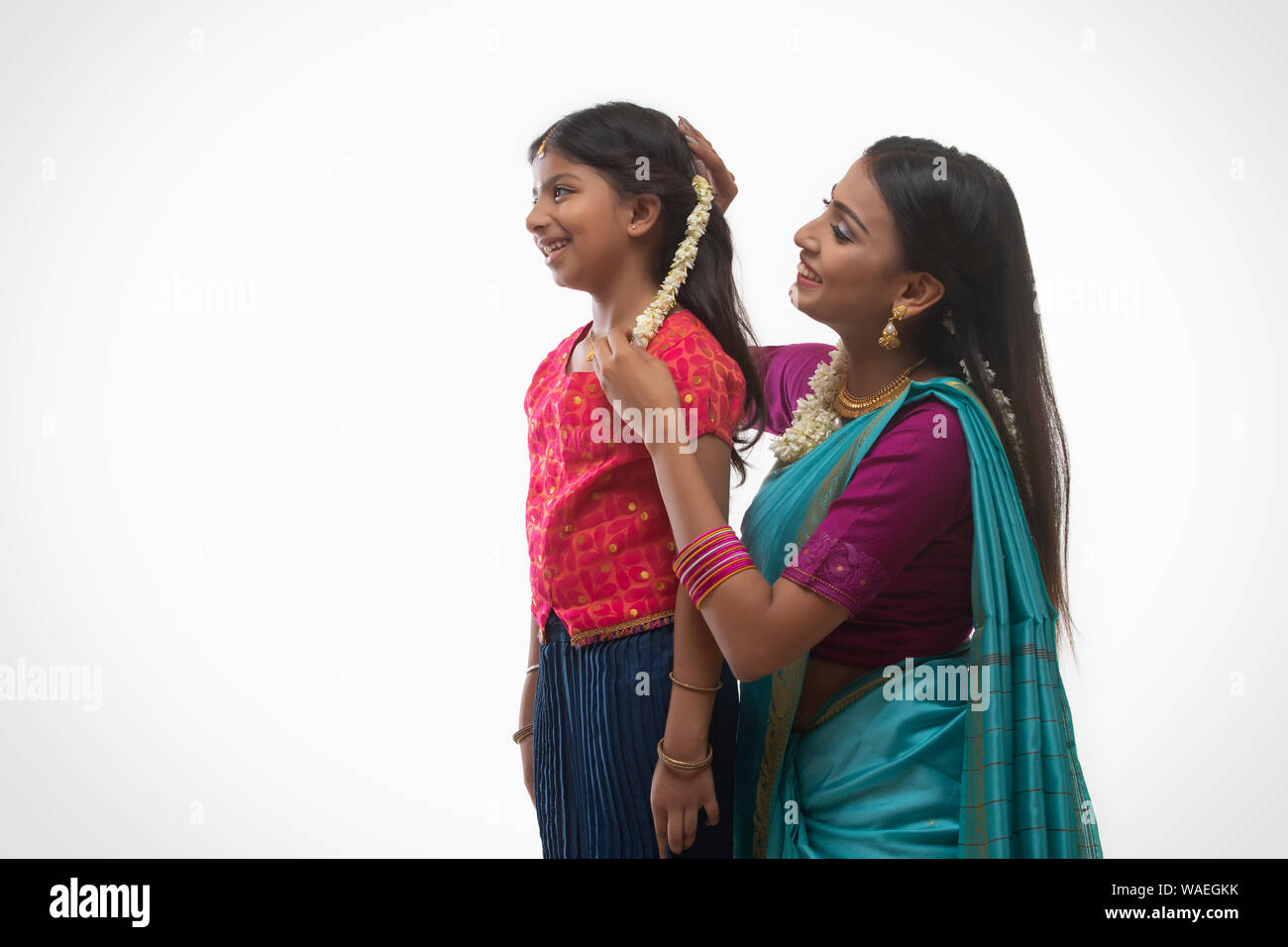Sud donna indiana mettendo gajra nelle sue figlie capelli Foto Stock