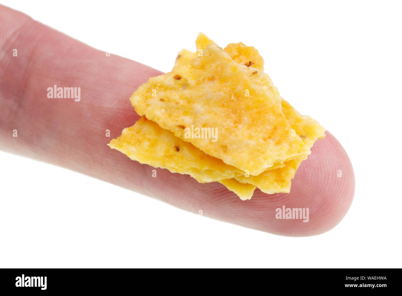 In futuro potremo mangiare questo concetto - piccolo brutto male potato chips briciole sul dito. Isolato su bianco studio macro Foto Stock