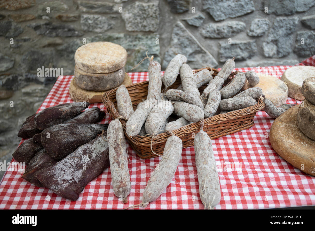 Artigianale di formaggi e salumi prodotti tipici italiani, esposto su un tavolo presso il locale mercato degli agricoltori. Foto Stock