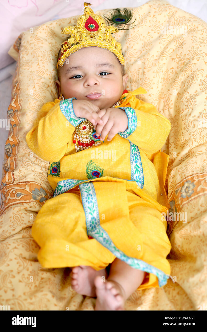 Foto di indiani bambina indossa Krishna costume e celebrando Janmashtami festival. Isolato sullo sfondo bianco. Foto Stock