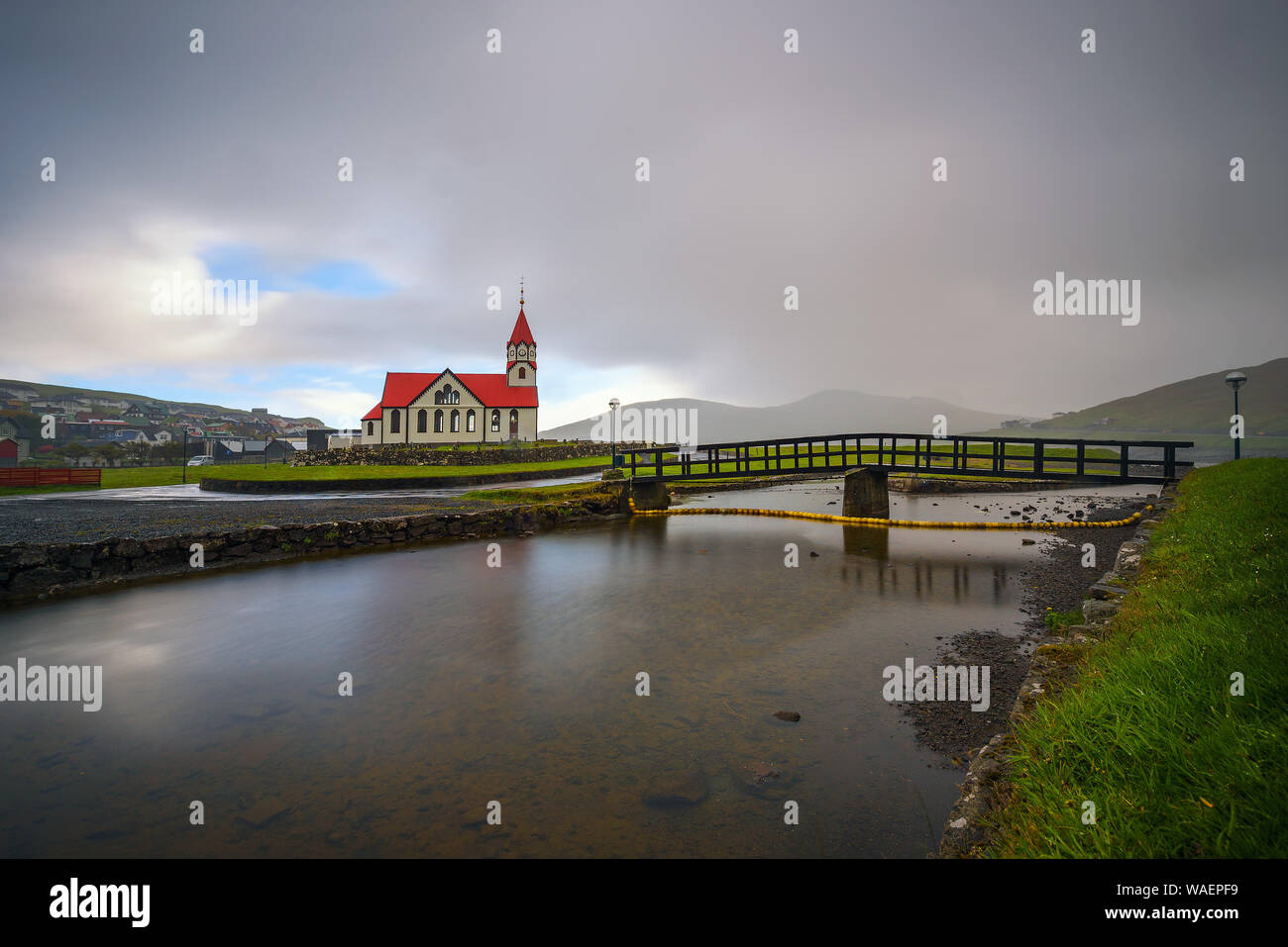 La chiesa e il fiume Stora situato in Sandavagur su isole Faerøer, Danimarca Foto Stock