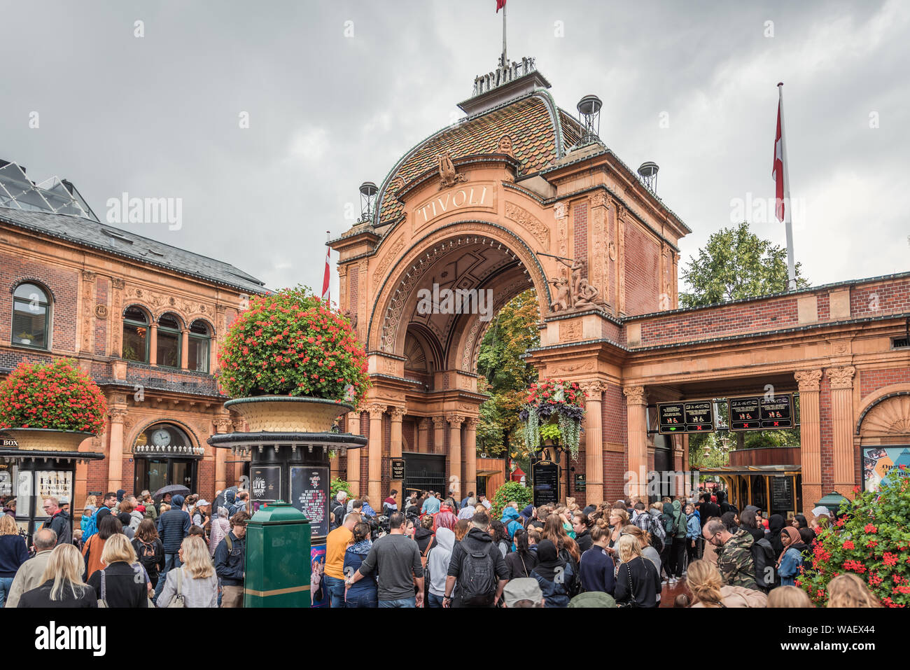 I visitatori a piedi attraverso il portale dei giardini di Tivoli a Copenhagen, in Danimarca, 16 agosto 2019 Foto Stock