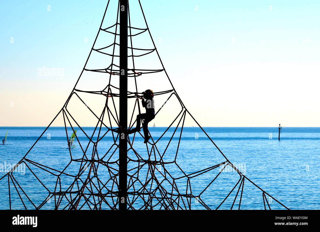 Silhouette di un bambino arrampicata corda Foto Stock