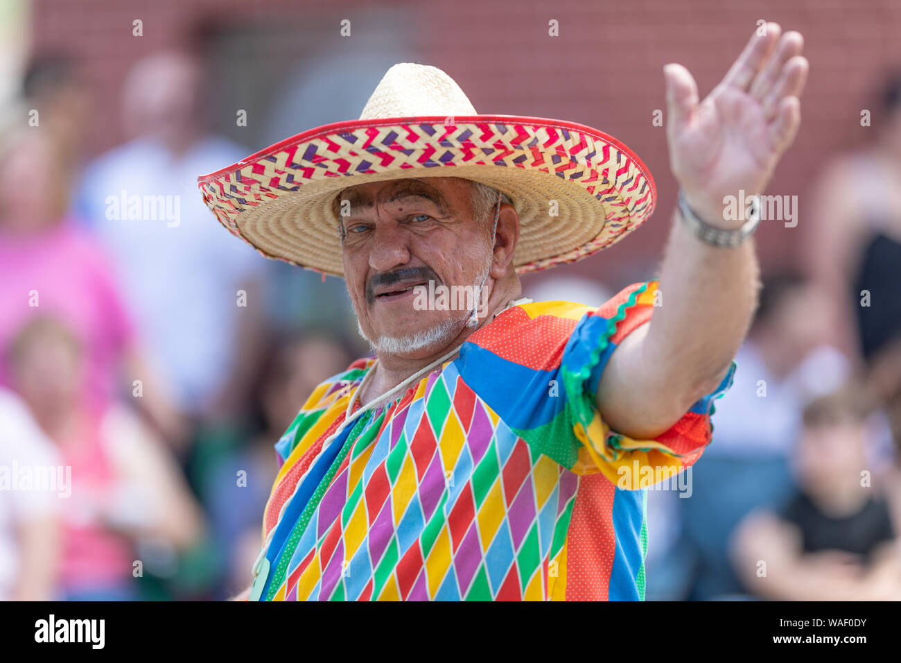 Buckhannon, West Virginia, Stati Uniti d'America - 18 Maggio 2019: fragola Festival, uomo che indossa un vestito da clown, con un messicano sombrero, sorridente sventolando la fotocamera A Foto Stock