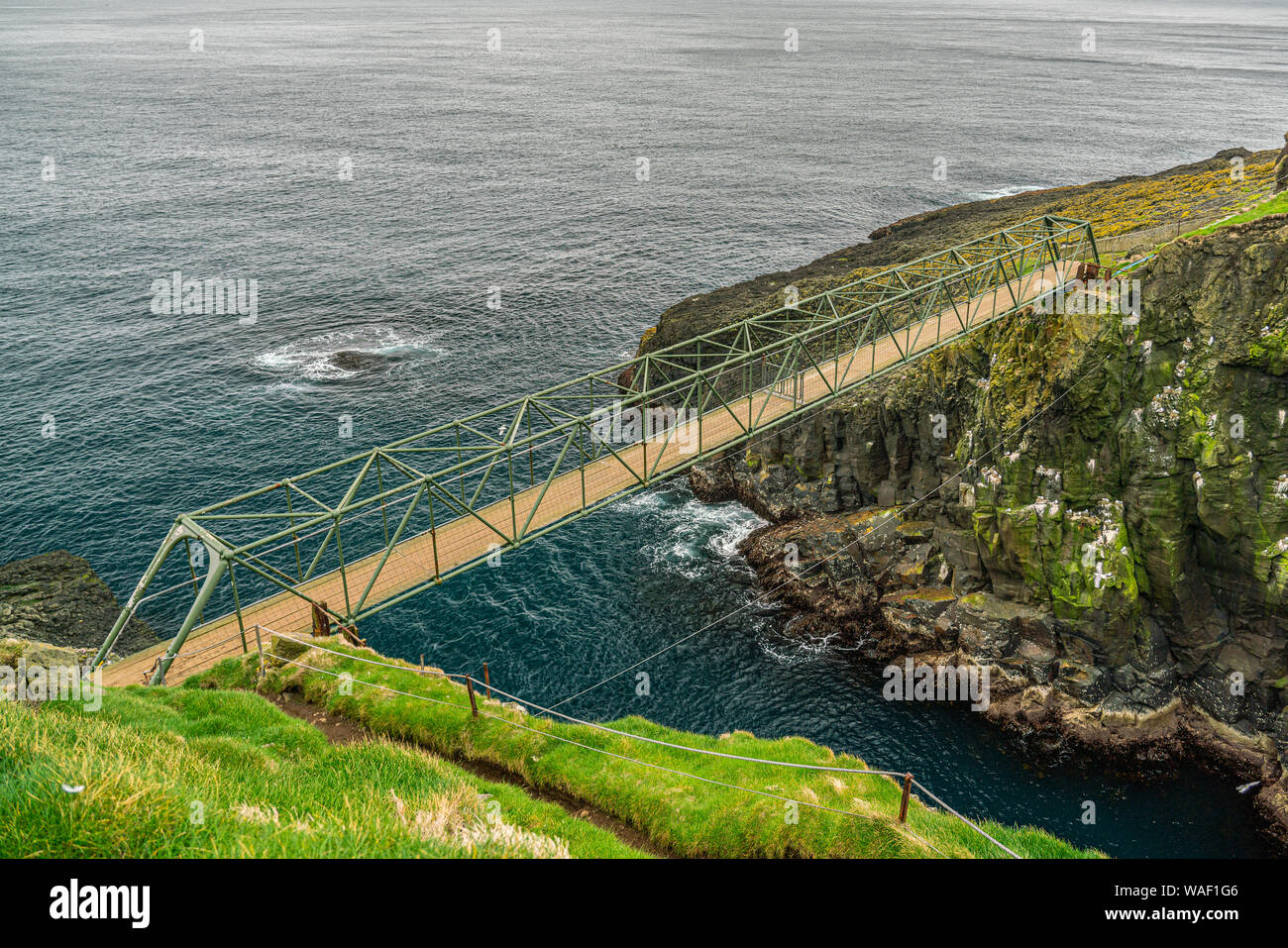 Ponte di Mykines unendo due lati dell'isola, isole Faerøer Foto Stock
