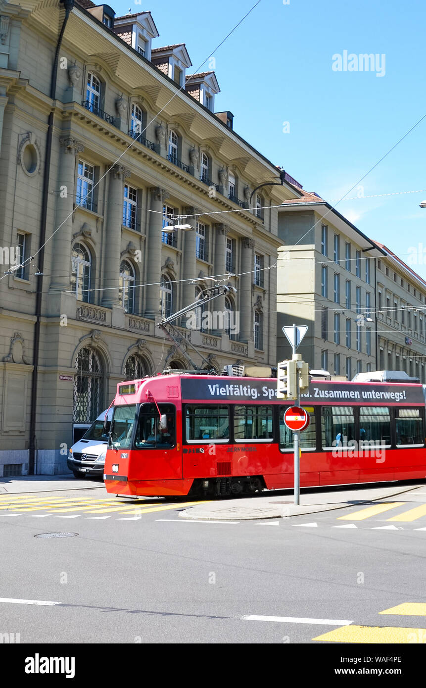 Bern, Svizzera - 14 agosto 2019: tram rosso nel centro della capitale della Svizzera. Luce rossa sulle strisce pedonali, città incrocio. Edifici storici. Soleggiata giornata estiva. Foto Stock