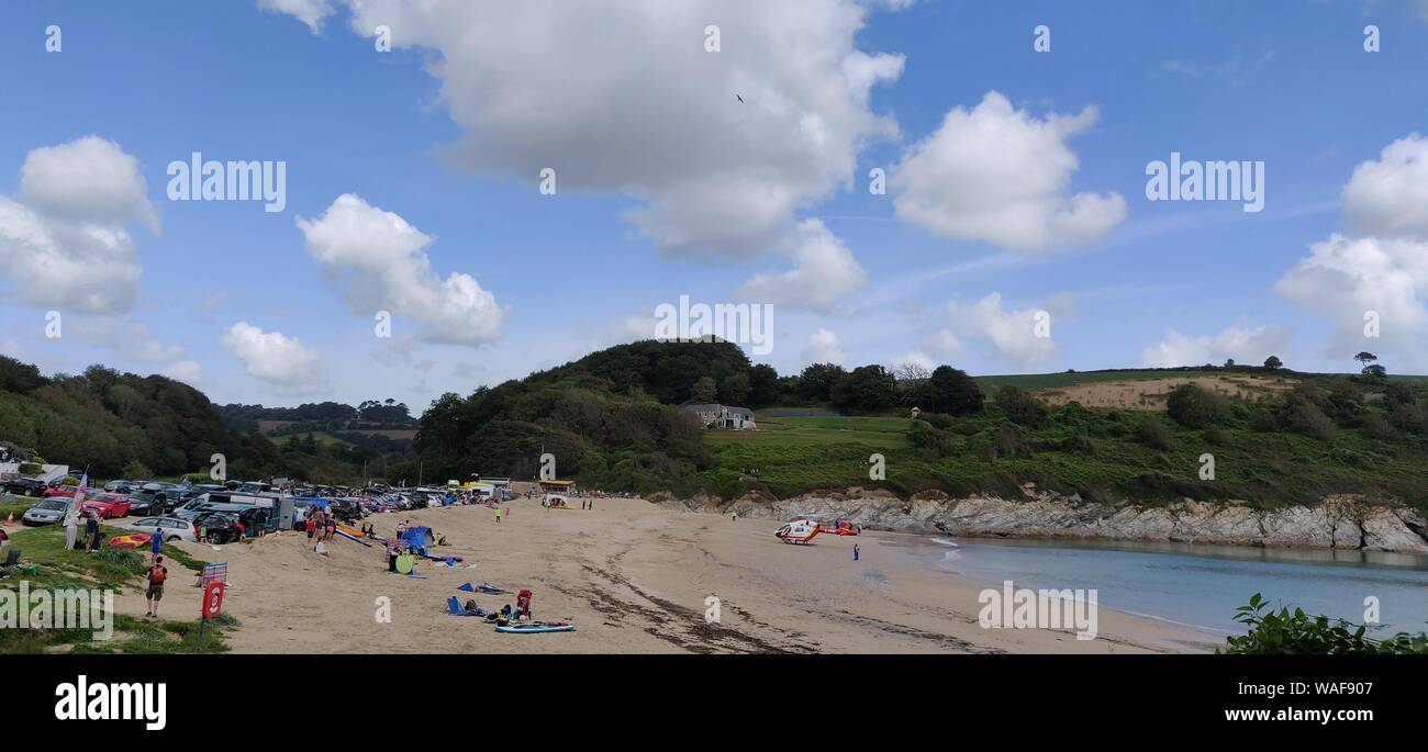 Maenporth, Cornwall, Regno Unito. 20 Agosto, 2019. Beachgoers a Maenporth, Cornovaglia sono stati liquidati fuori dalla spiaggia per consentire un aereo ambulanza a terra per prelevare un incidente. La Air Ambulance sbarcati e poi ha preso il largo di nuovo a terra in un campo nelle vicinanze. La vittima è stata presa per il campo da dove l'elicottero ha preso lui/lei in ospedale.L'incidente ha cominciato appena prima di mezzogiorno.Le immagini sono state prese da una strada pubblica. Credito: newspix/Alamy Live News Foto Stock