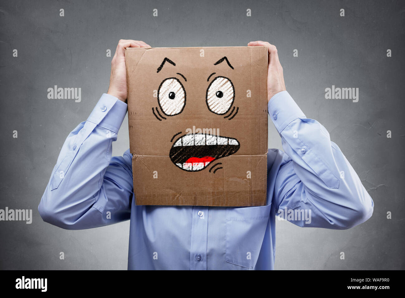 Imprenditore con scatola di cartone sulla sua testa che mostra un scioccato e sorpreso espressione concetto di espressione per il mancato, sorpresa, paura, ansia o disbe Foto Stock
