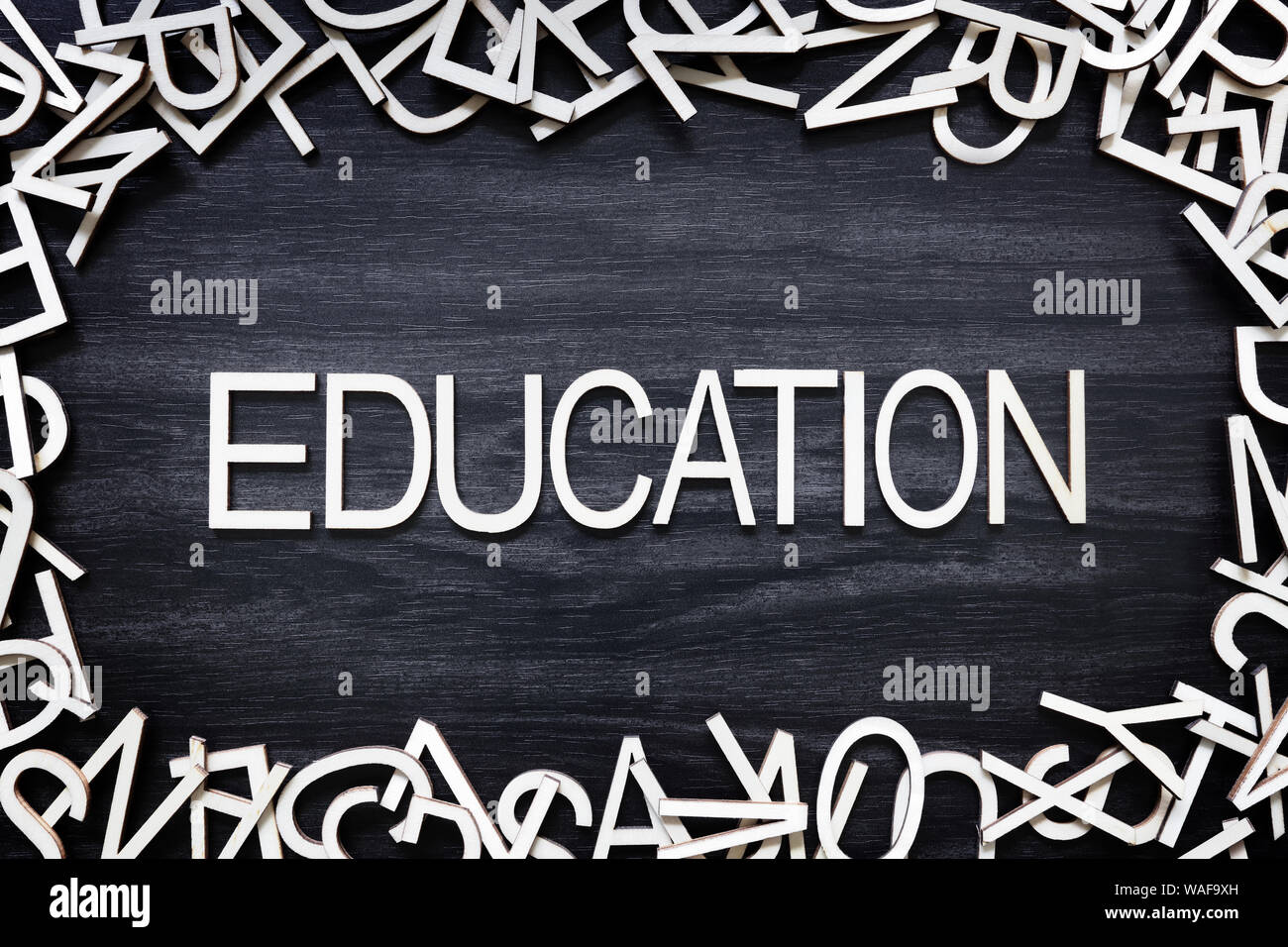 Istruzione lettere di legno sul bordo nero Foto Stock