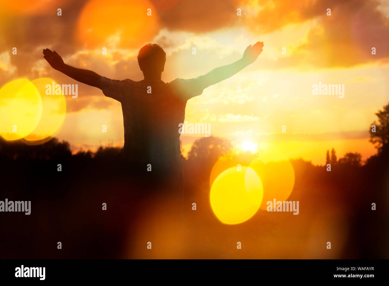 Silhouette di un uomo con le mani alzate nel concetto di tramonto per la religione, il culto e la preghiera e lode Foto Stock