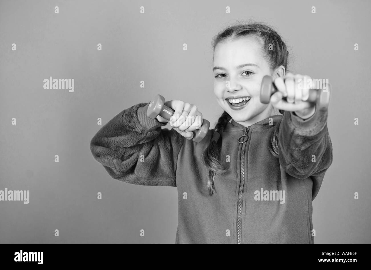 Bambino felice sportivo con barbell. Dieta Fitness per energia salute. allenamento di piccola ragazza sportivo a tenere il manubrio. sollevamento pesi per muscules. Attività dell infanzia. Sport di successo. sicuri di uno sportivo. Foto Stock