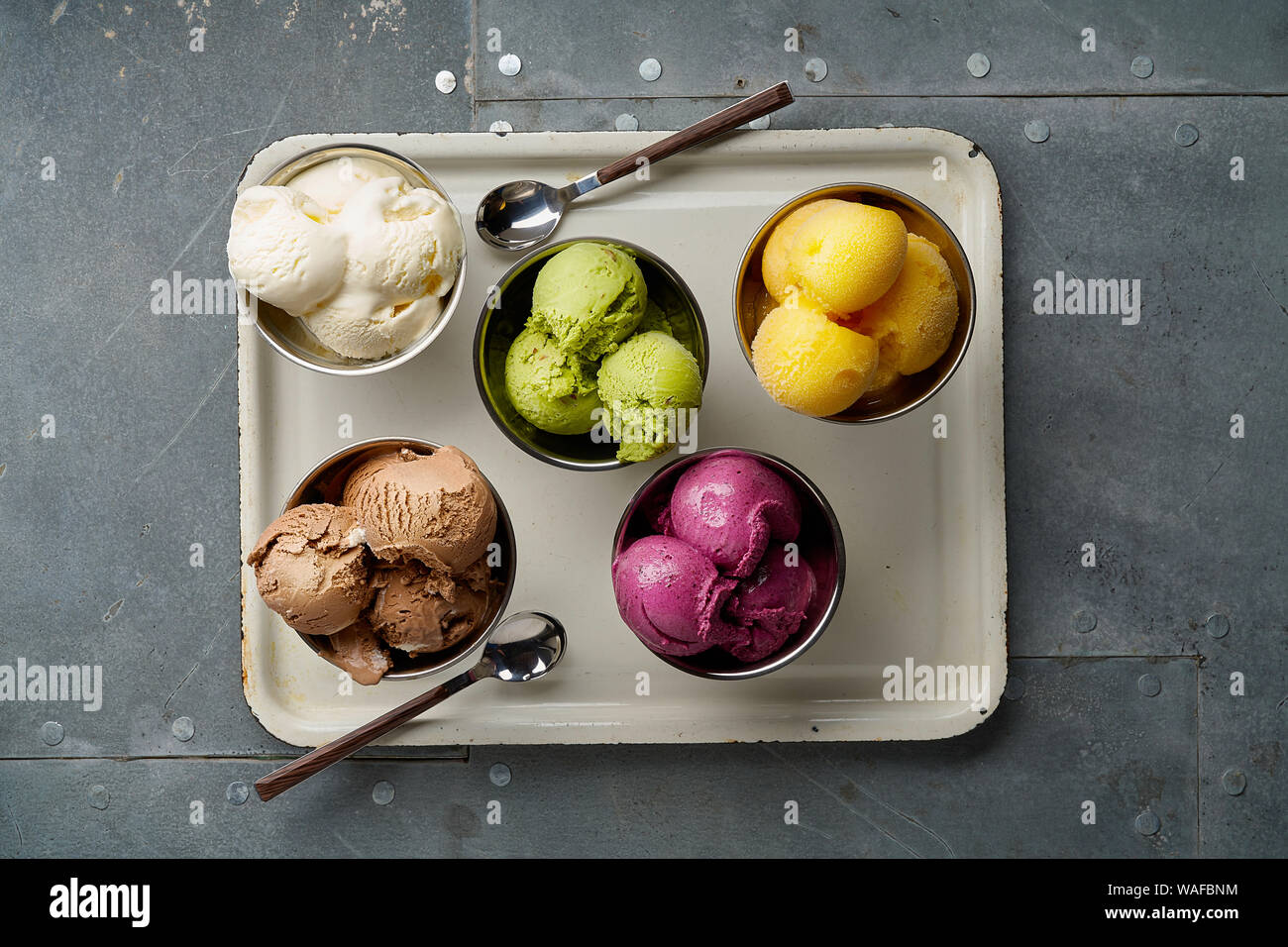 Un assortimento di sapori e colori di gourmet gelato italiano servito sul tavolo in acciaio. Mango, cioccolato, Verde matcha ice cream Foto Stock