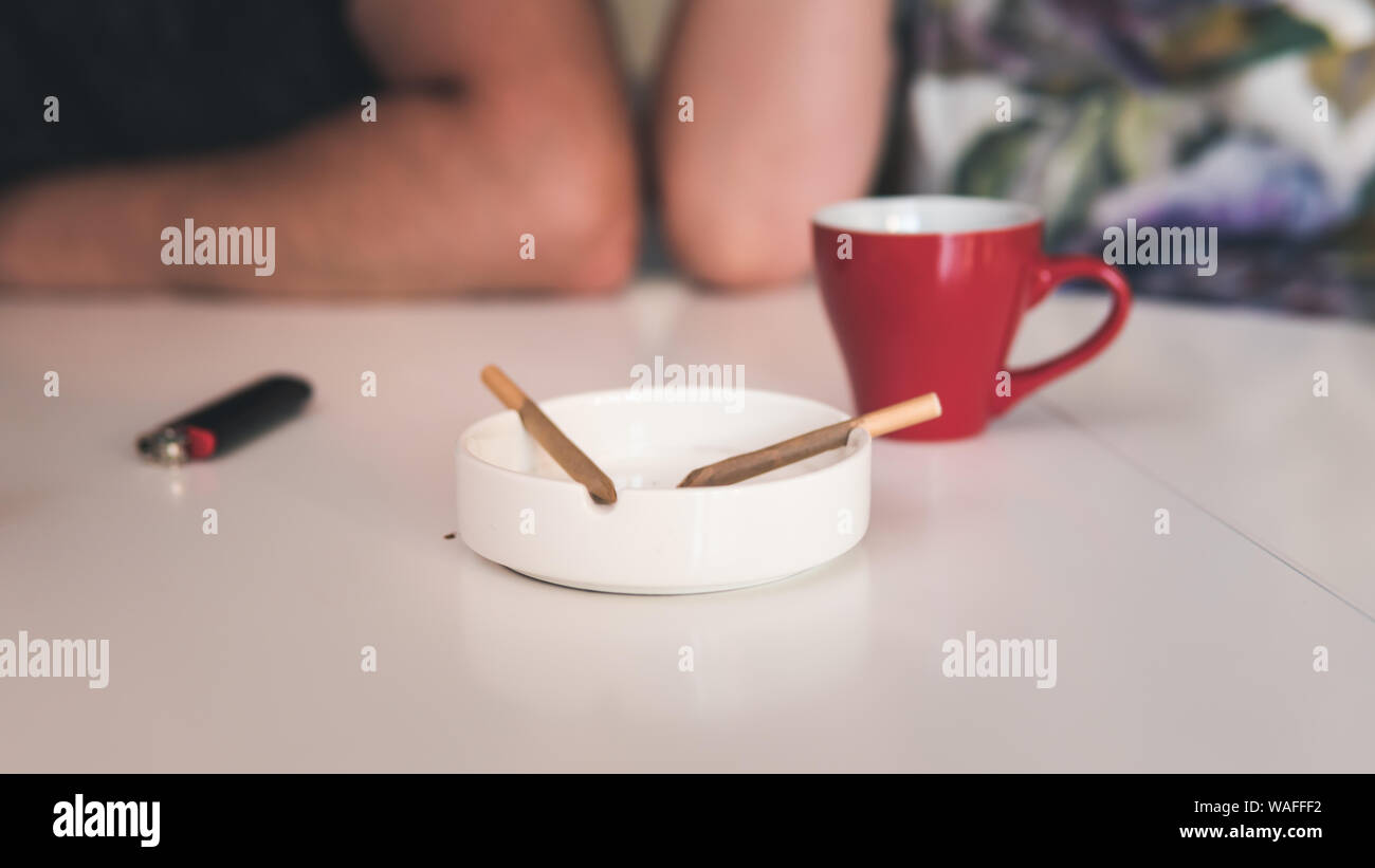 Due per la marijuana medica si unisce in un portacenere, una tazza di caffè e leggero vicino a. Fumare marijuana giunto all'interno. La cannabis è un concetto di erbe med Foto Stock