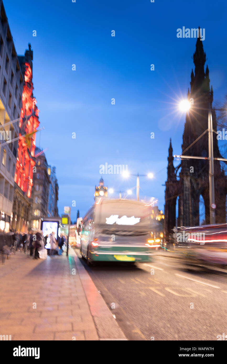 Immagine astratta del traffico notturno in Princes Street Edinburgh Scotland Regno Unito .vista notturna con veicoli sfocate, traffico e persone Foto Stock
