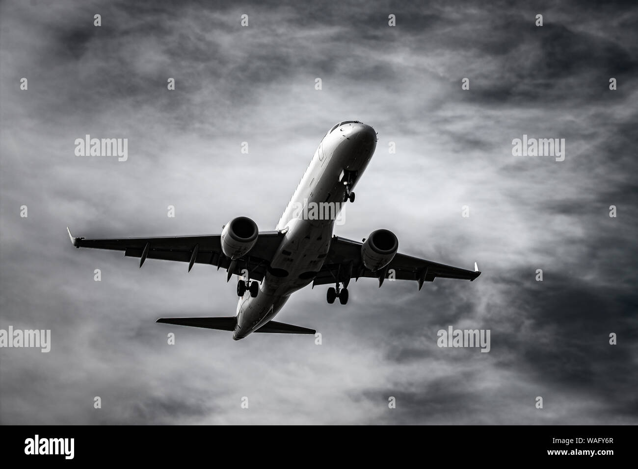 Atterraggio aereo nella parte anteriore del cielo drammatico in bianco e nero Foto Stock