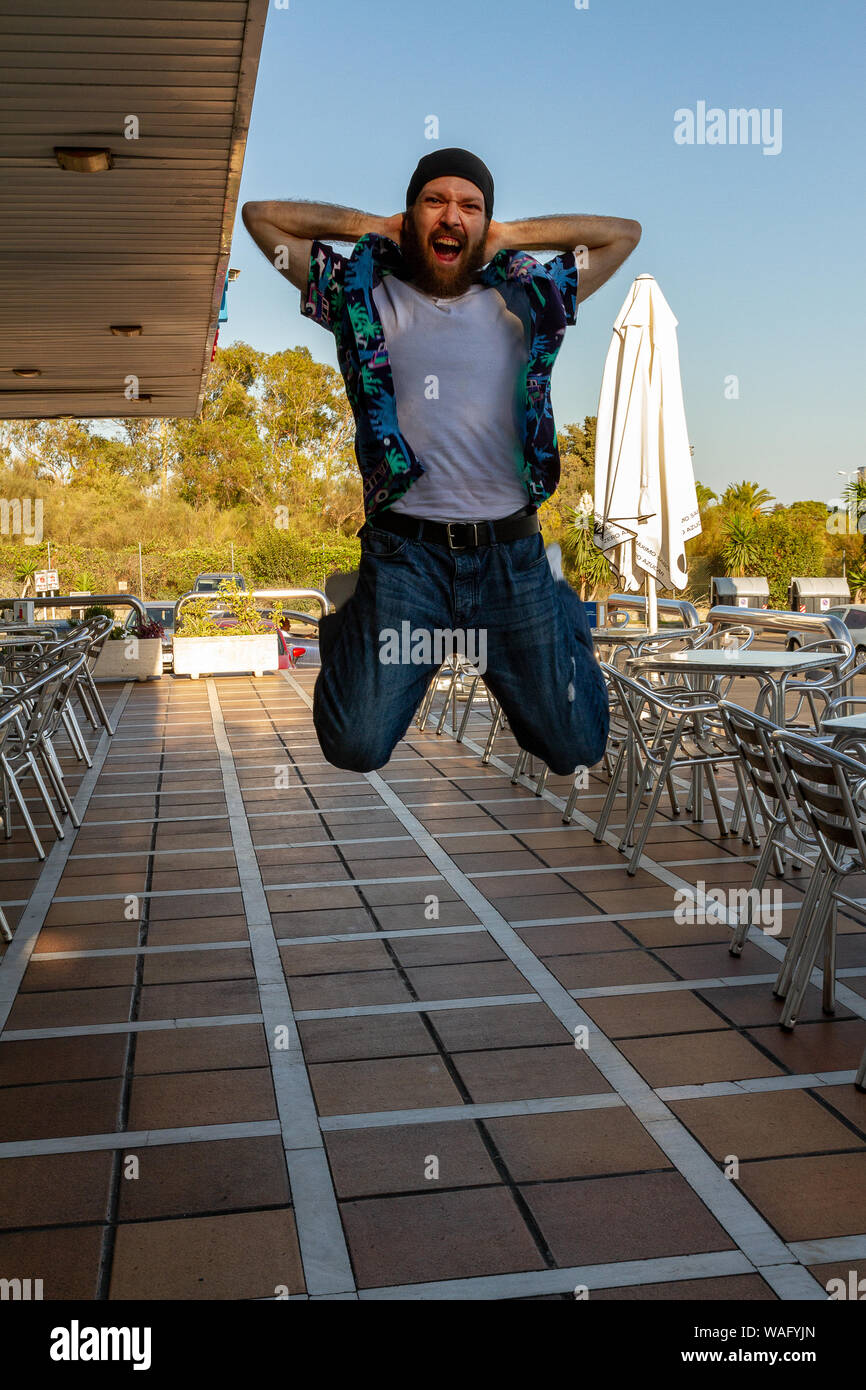 Giovane uomo jumping happy con la barba e velo Foto Stock