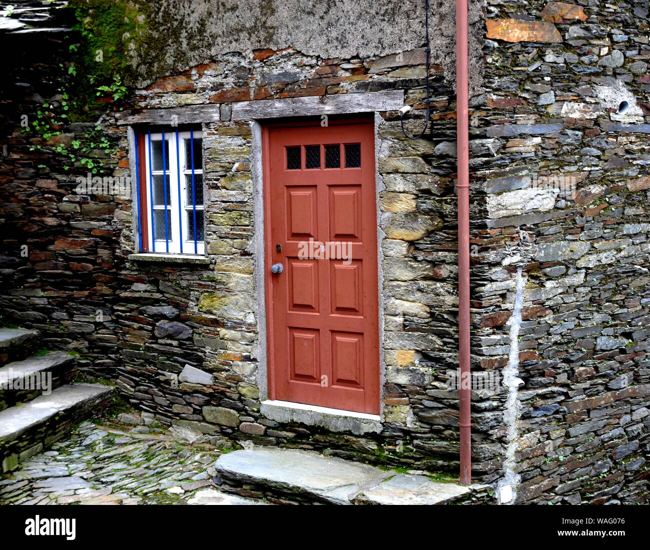 Rustico mano-scavato nella porta di legno inserito in una parete di pietra costruito da scisto in Piodão, fatta di rocce argillose stack, uno del Portogallo villaggi scisti nell'ALDE Foto Stock