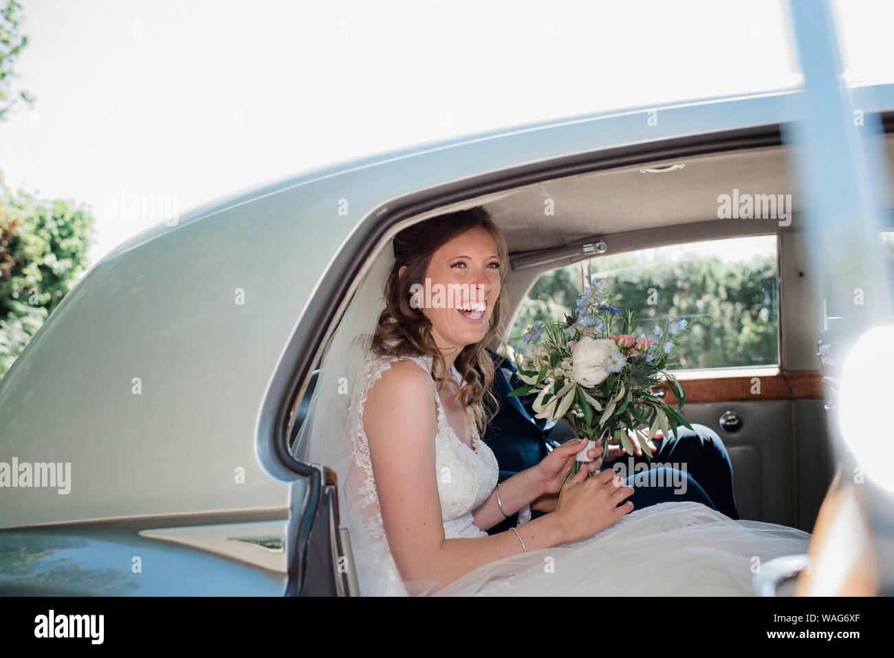 Ritratto di sposa sorridente e si sedette con il suo boquet sul suo giorno di nozze Foto Stock