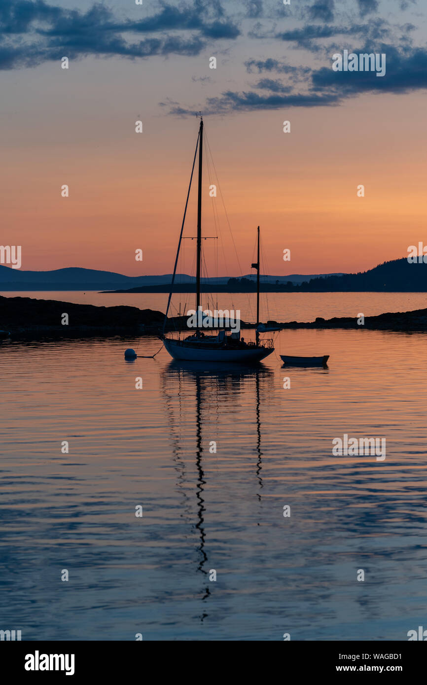 Una scialuppa concordia si siede su un ormeggio off Isola di zucca, Maine al tramonto Foto Stock