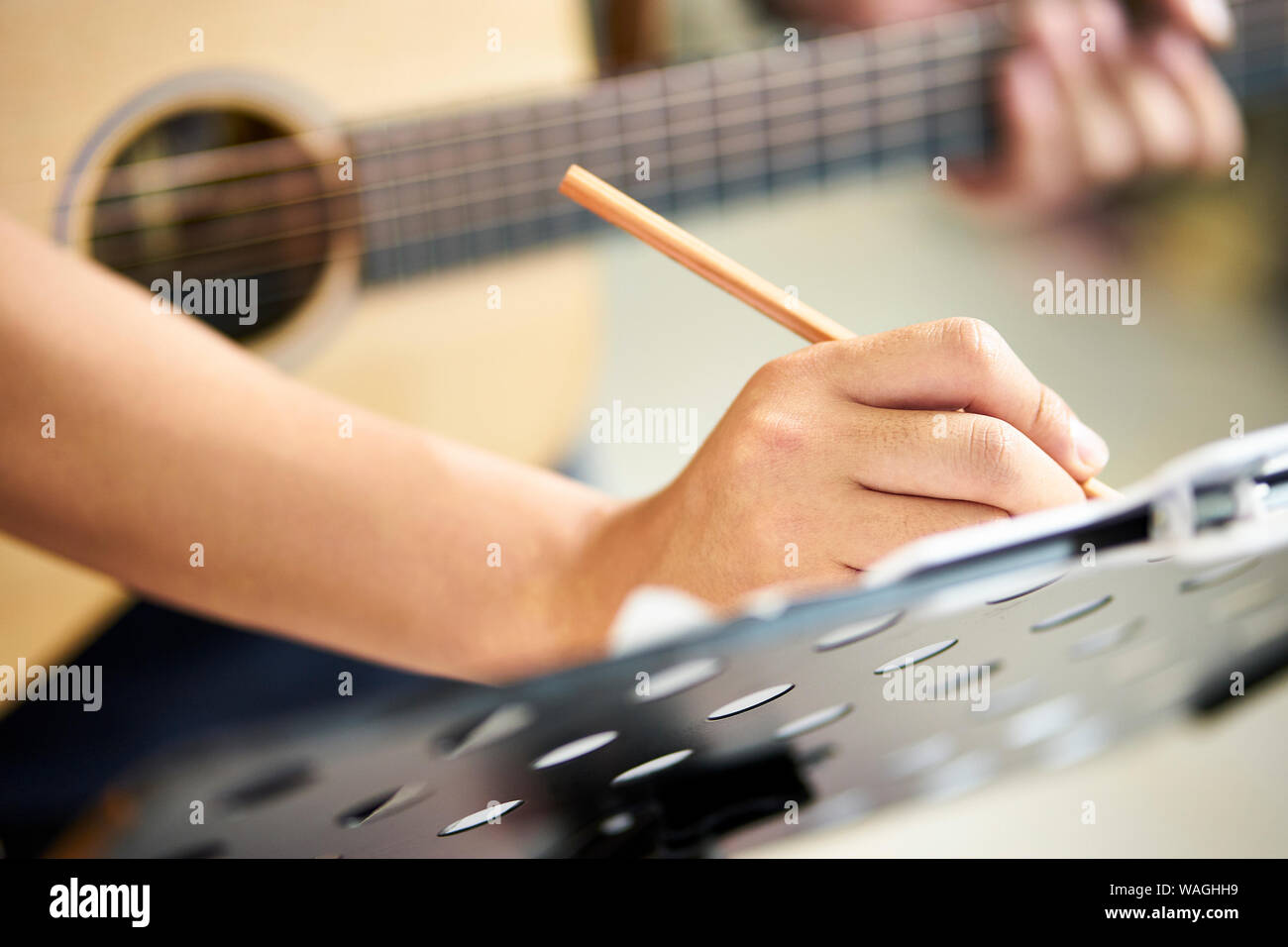Close-up shot della mano di un chitarrista di prendere appunti durante la composizione di musica Foto Stock