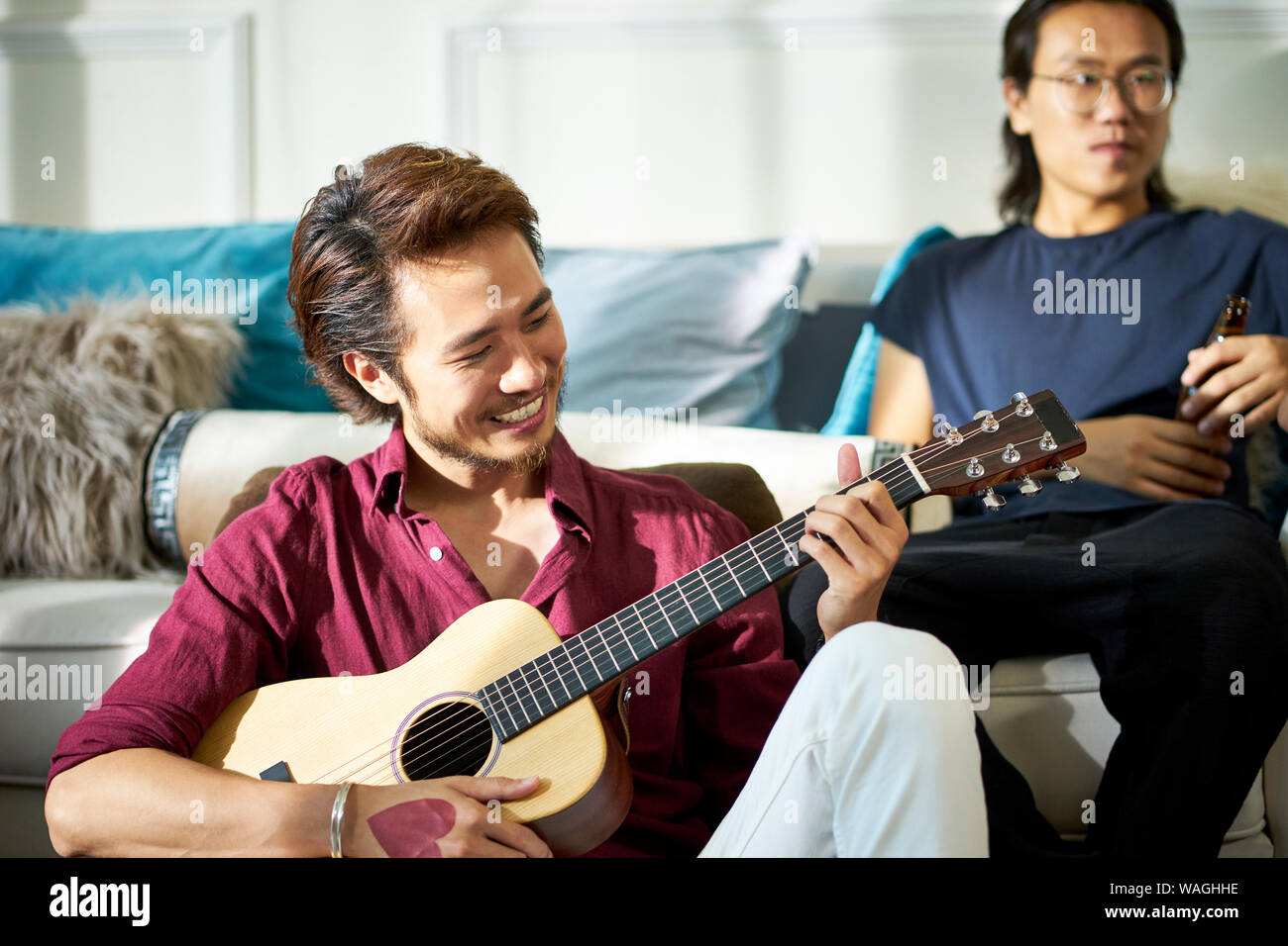 Asian giovani uomini adulti rilassarsi e godersi musica e birra a parte Foto Stock