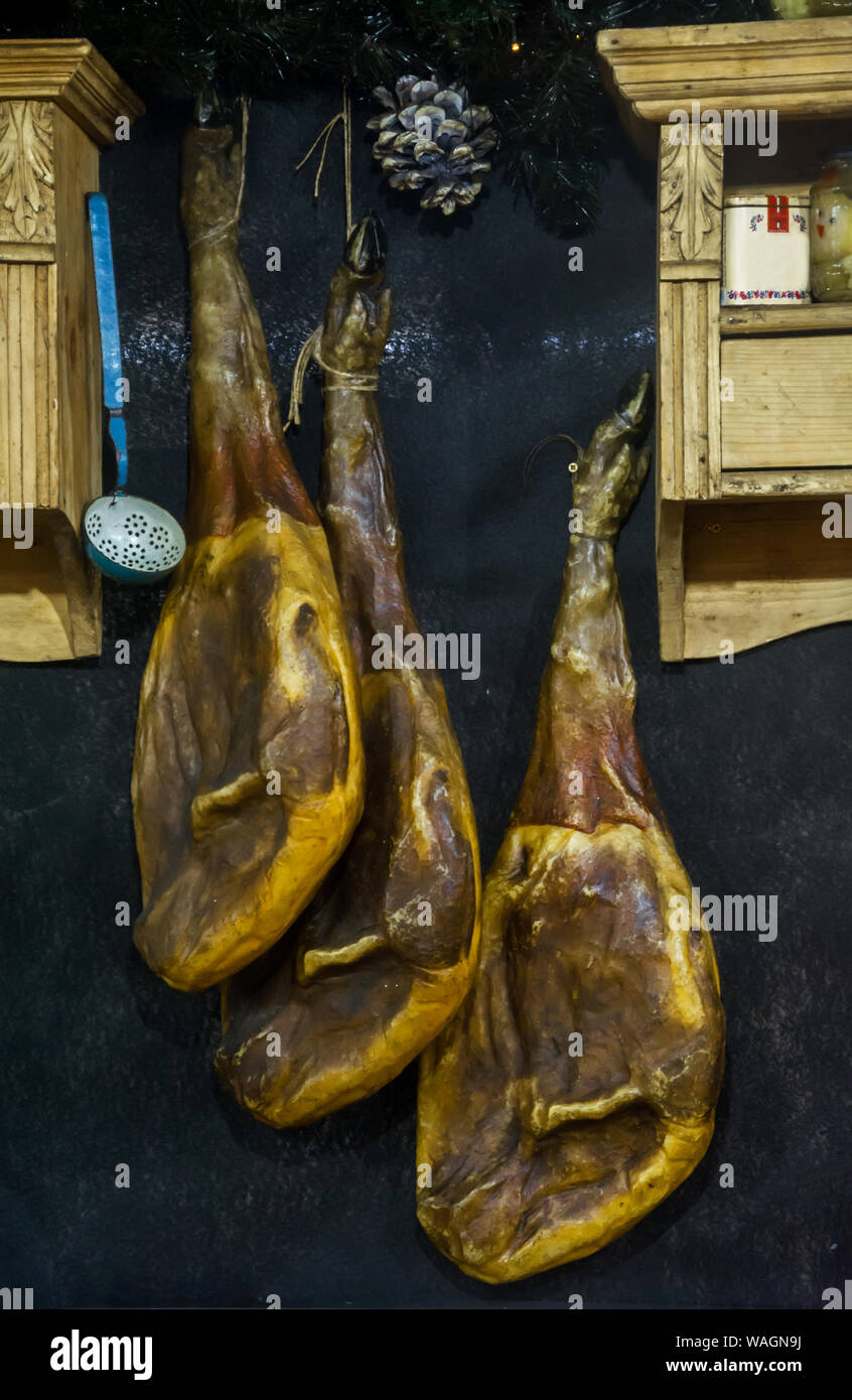 I prosciutti appesi. Jamón appeso su una casa rustica. Il prosciutto appeso in un villaggio rustico cucina. Sospeso, induriti coscia di maiale per il prosciutto. Foto Stock