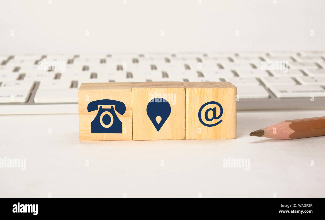 Icone di contatto sui blocchi di legno con tastiera, Contattaci concept Foto Stock