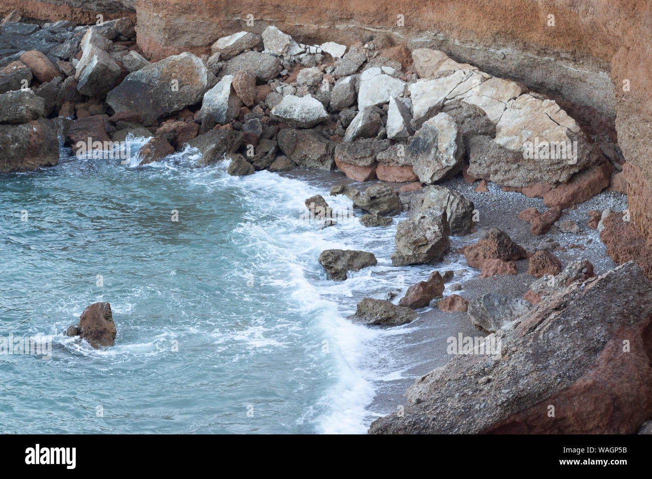 Rocce è sprofondato in una spiaggia sotto una rupe Foto Stock