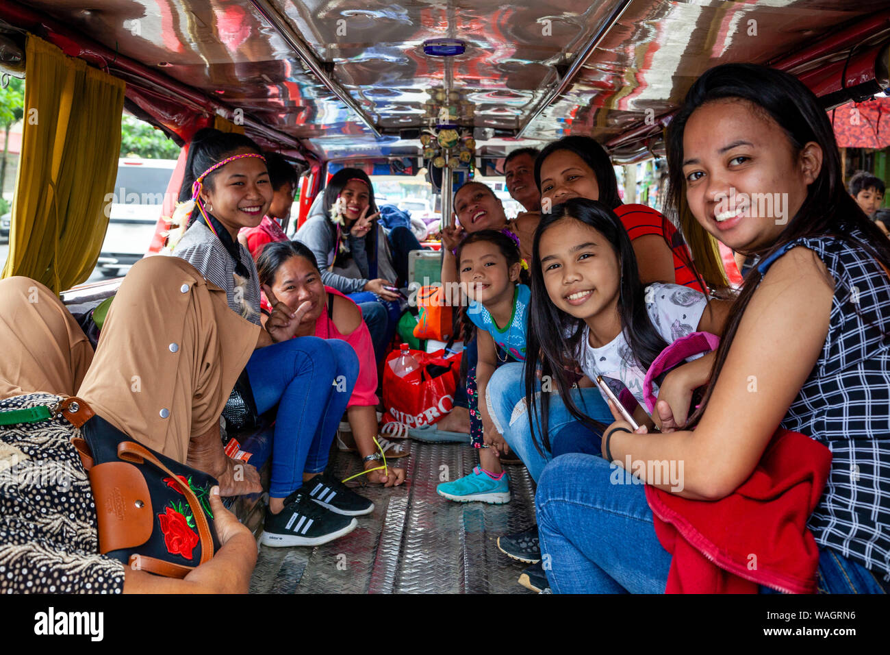 Felice il popolo filippino seduta all'interno di un Jeepney in attesa di partire, Kalibo, Panay Island, Aklan Provincia delle Filippine. Foto Stock