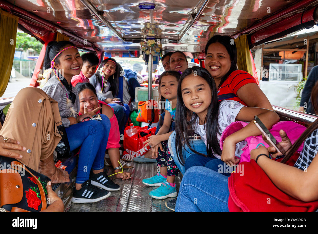 Felice il popolo filippino seduta all'interno di un Jeepney in attesa di partire, Kalibo, Panay Island, Aklan Provincia delle Filippine. Foto Stock