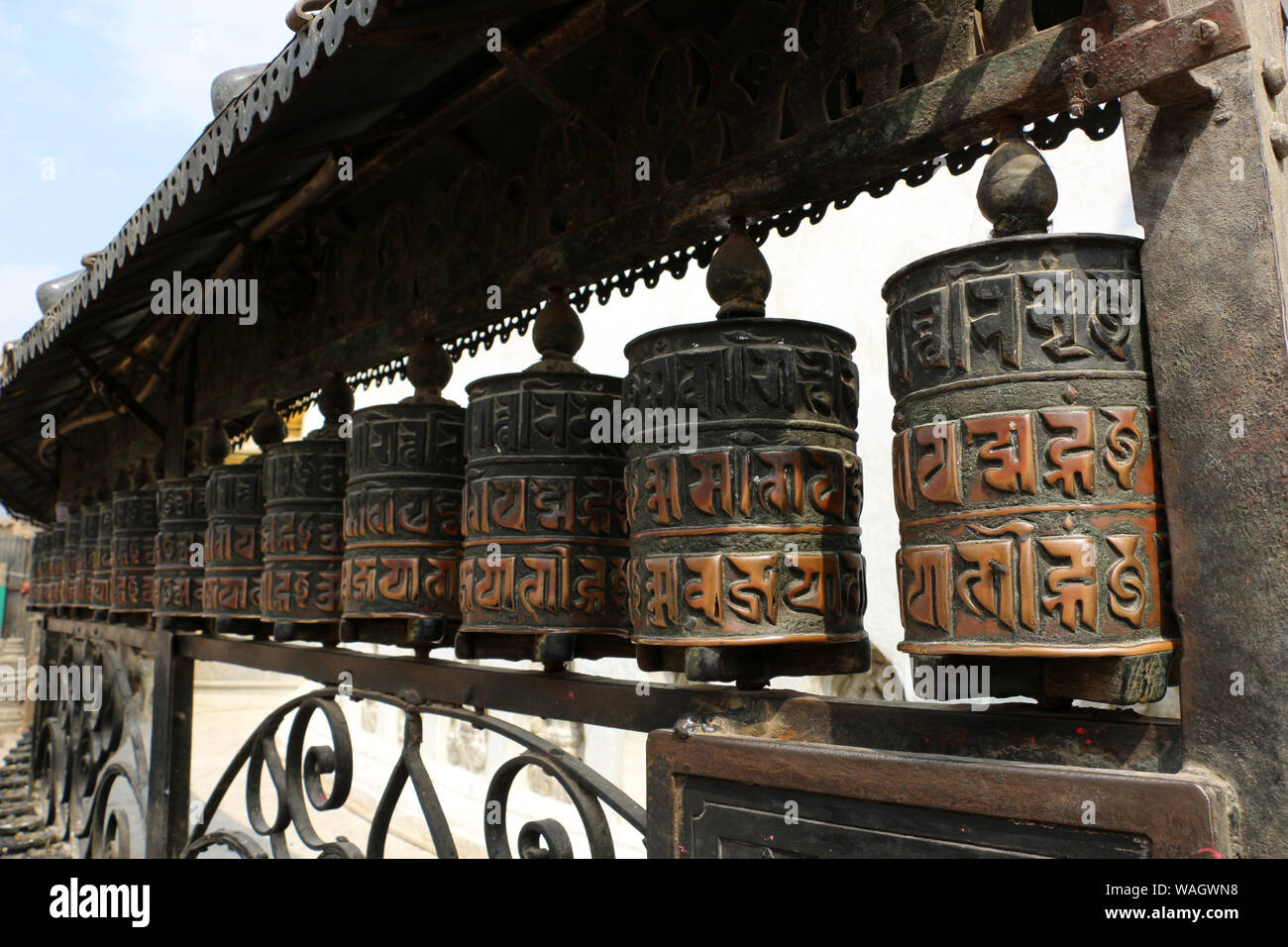 Tradizionalmente il mantra Om mani padme Hum è scritto in lingua Newari del Nepal, sul lato esterno della ruota. Foto Stock