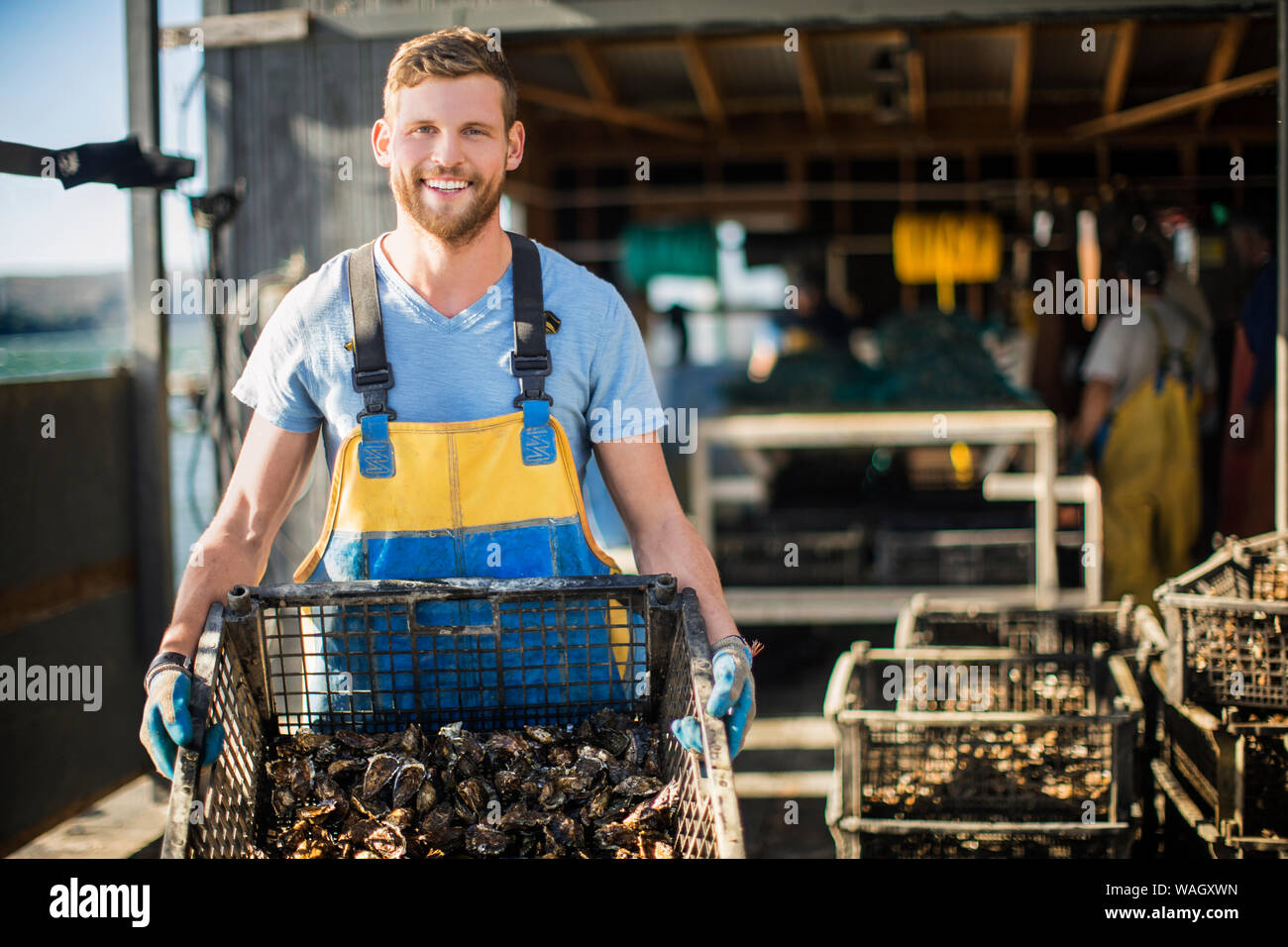 Giovane uomo mostra catturati i molluschi e i crostacei. Foto Stock